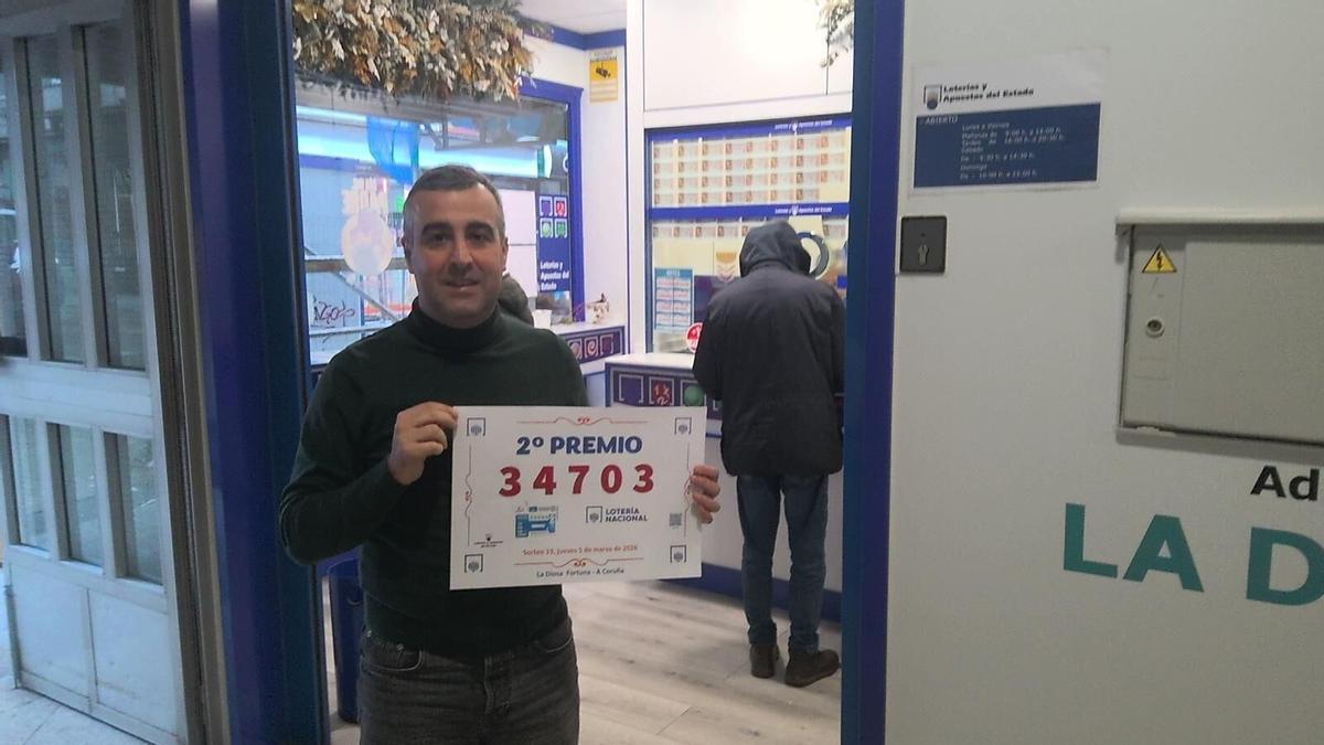 El administrador de La Diosa de la Fortuna posa con el número premiado, 34.703.