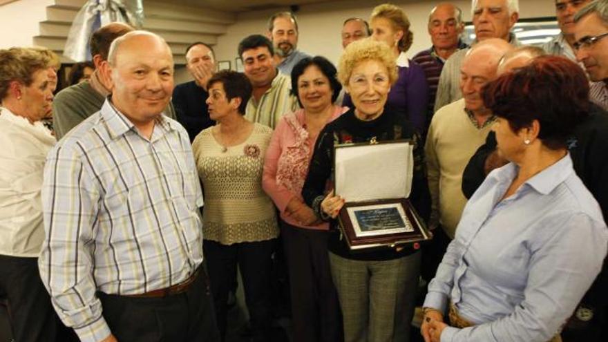 La profesora, en el centro con la placa, rodeada de sus ex alumnos.