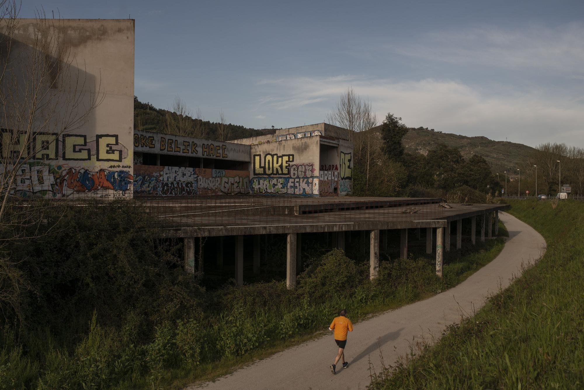 El fallido centro de interpretación de parques naturales. Su esqueleto de hormigón, lleno de pintadas, recibe al viajero en la N-120. // BRAIS LORENZO