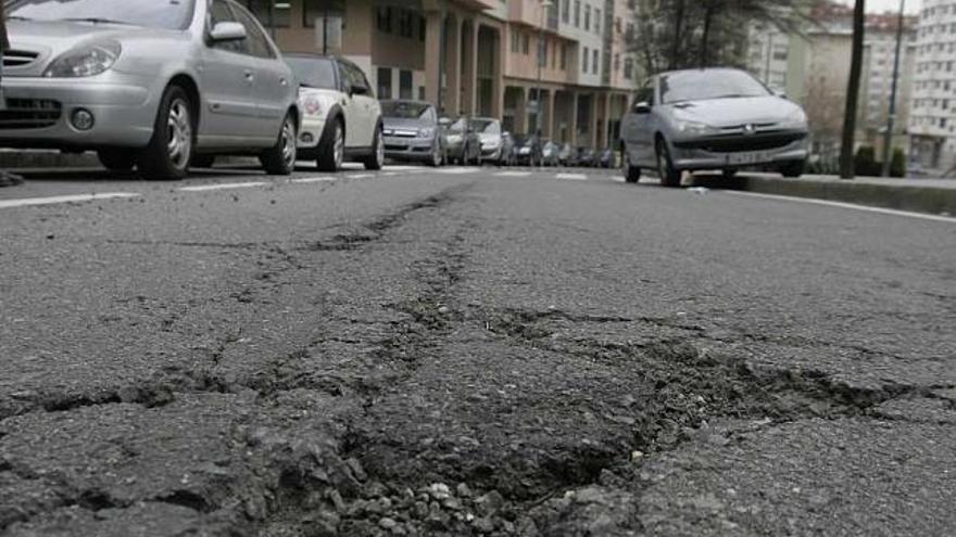 Baches y pavimento resquebrajado en Os Rosales. / eduardo vicente