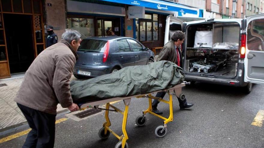 El traslado del cuerpo de Amador Suárez, con el portal de la vivienda a la izquierda.