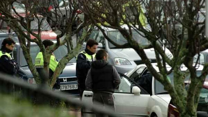 Varios policías identifican a un joven en las inmediaciones del instituto Sánchez Cantón.