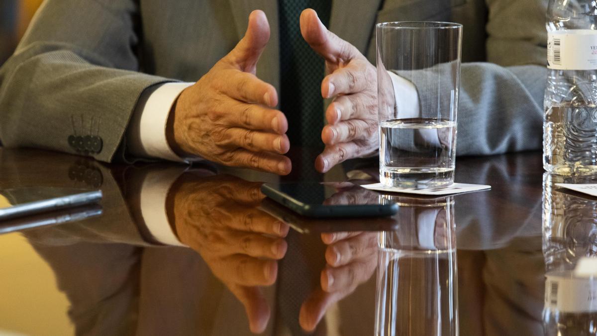Las manos del presidente y los móviles de la grabación, en la mesa de la entrevista.