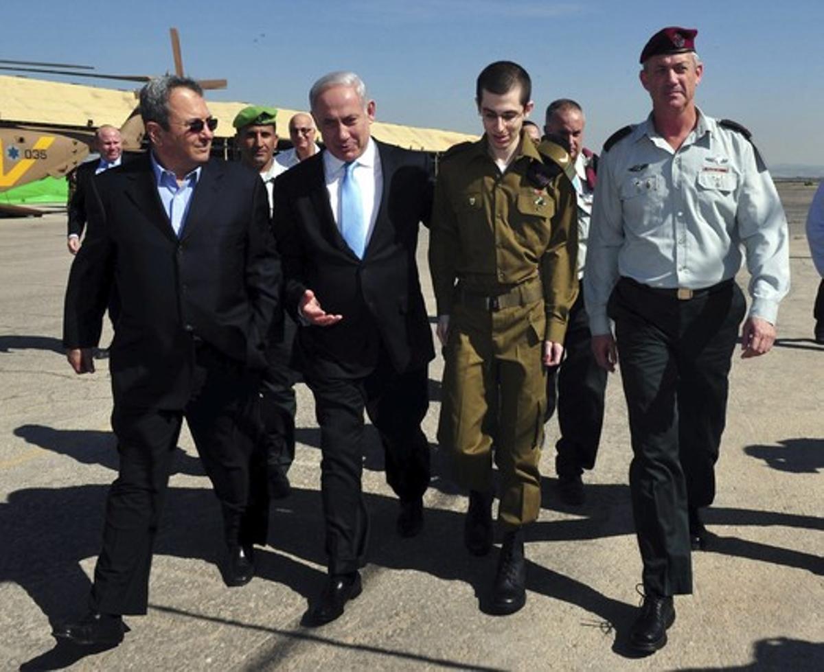 El primer ministre israelià Benjamin Netanyahu (segon a l’esq) camina amb el ministre de defensa israelià Ehud Barak (i), el soldat israelià alliberat Gilad Shalit (segon a la dre) i el general Benny Gantz a la Base Aèria de Tel Nof, Israel.