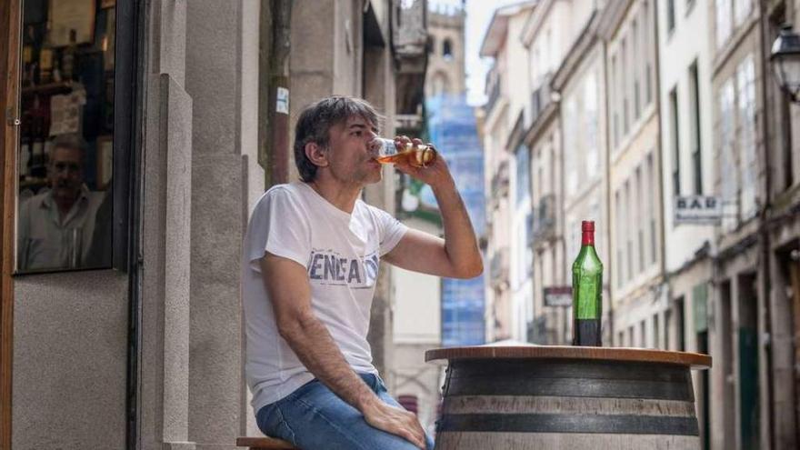 Juan Tallón apuraba ayer el vermú en el bar Cortés de la calle Lepanto, con la Catedral de Ourense al fondo. El dueño de la taberna, en el espejo. // Brais Lorenzo