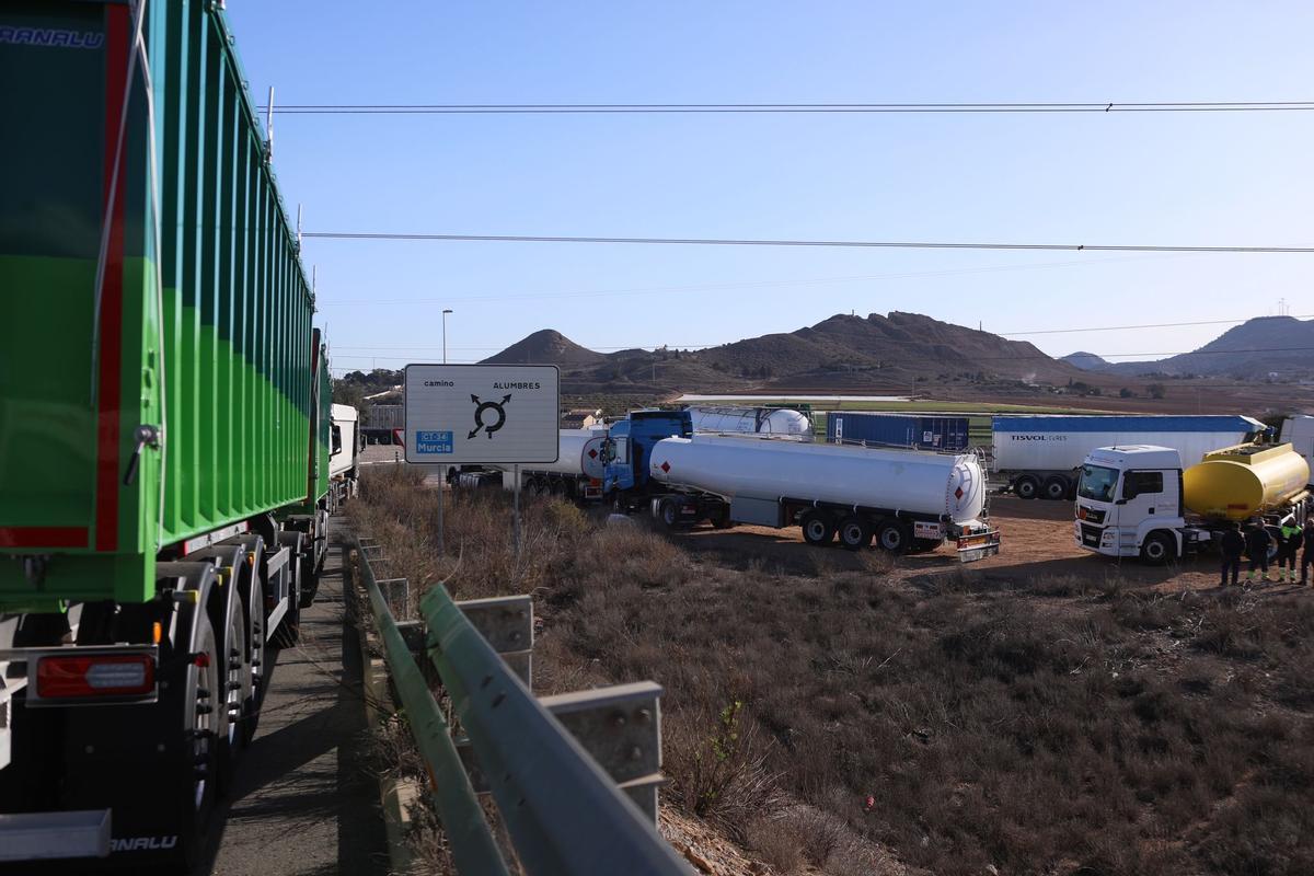 Camiones agurdan en la entrada de la rotonda que da acceso al Valle de Escombreras para poder continuar su ruta, esta mañana.