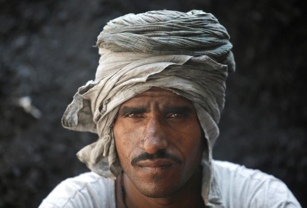 A worker poses as he takes a break at a coal ...