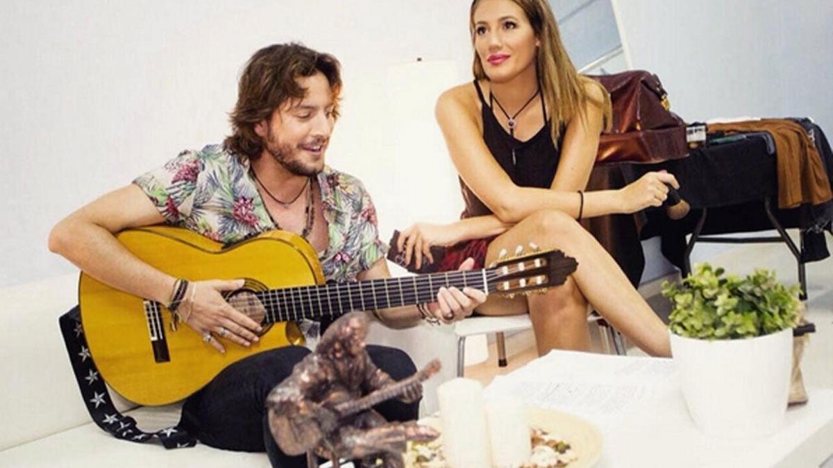 Manueol Carrasco con una guitarra le canta a Almudena Navalón