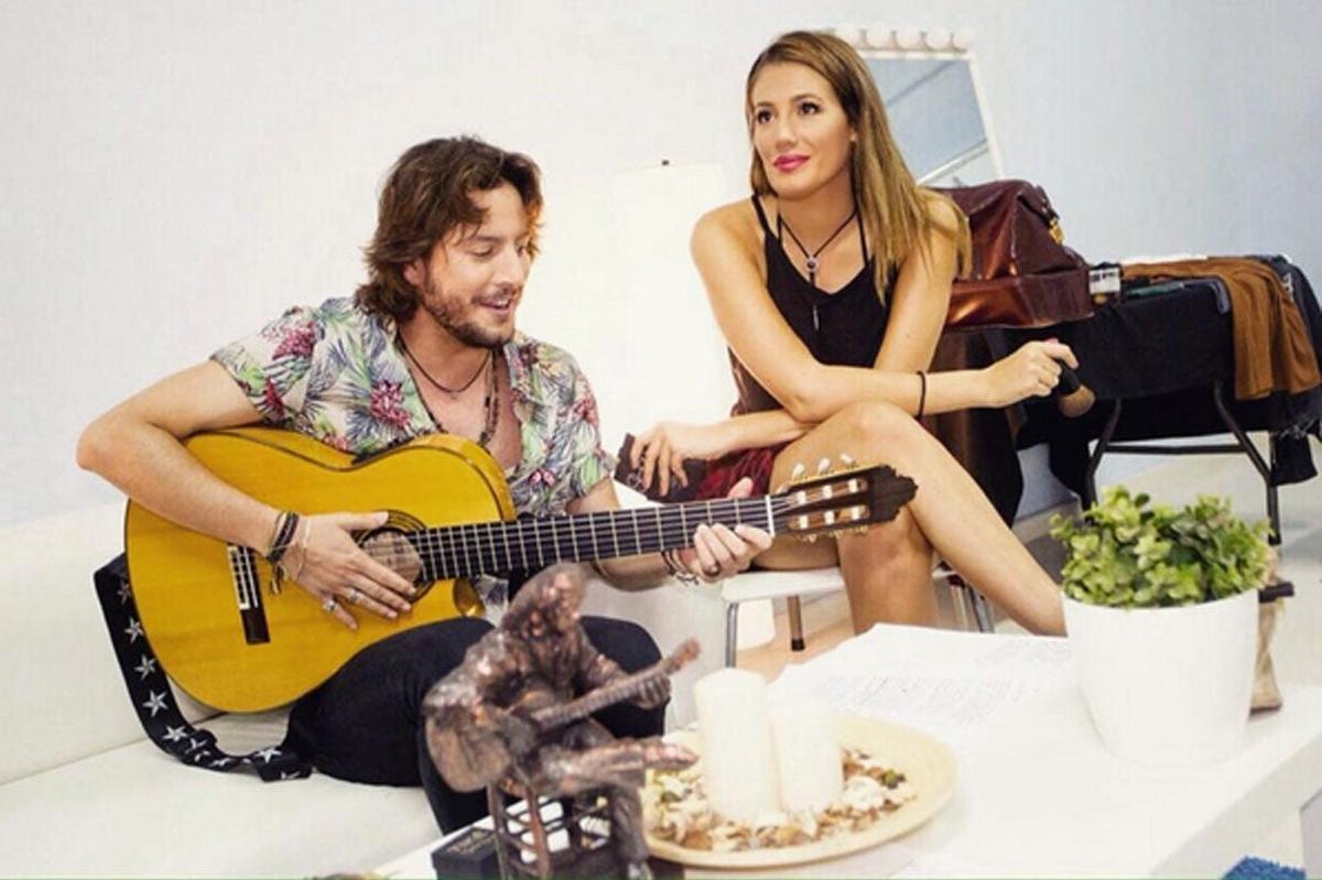 Manueol Carrasco con una guitarra le canta a Almudena Navalón