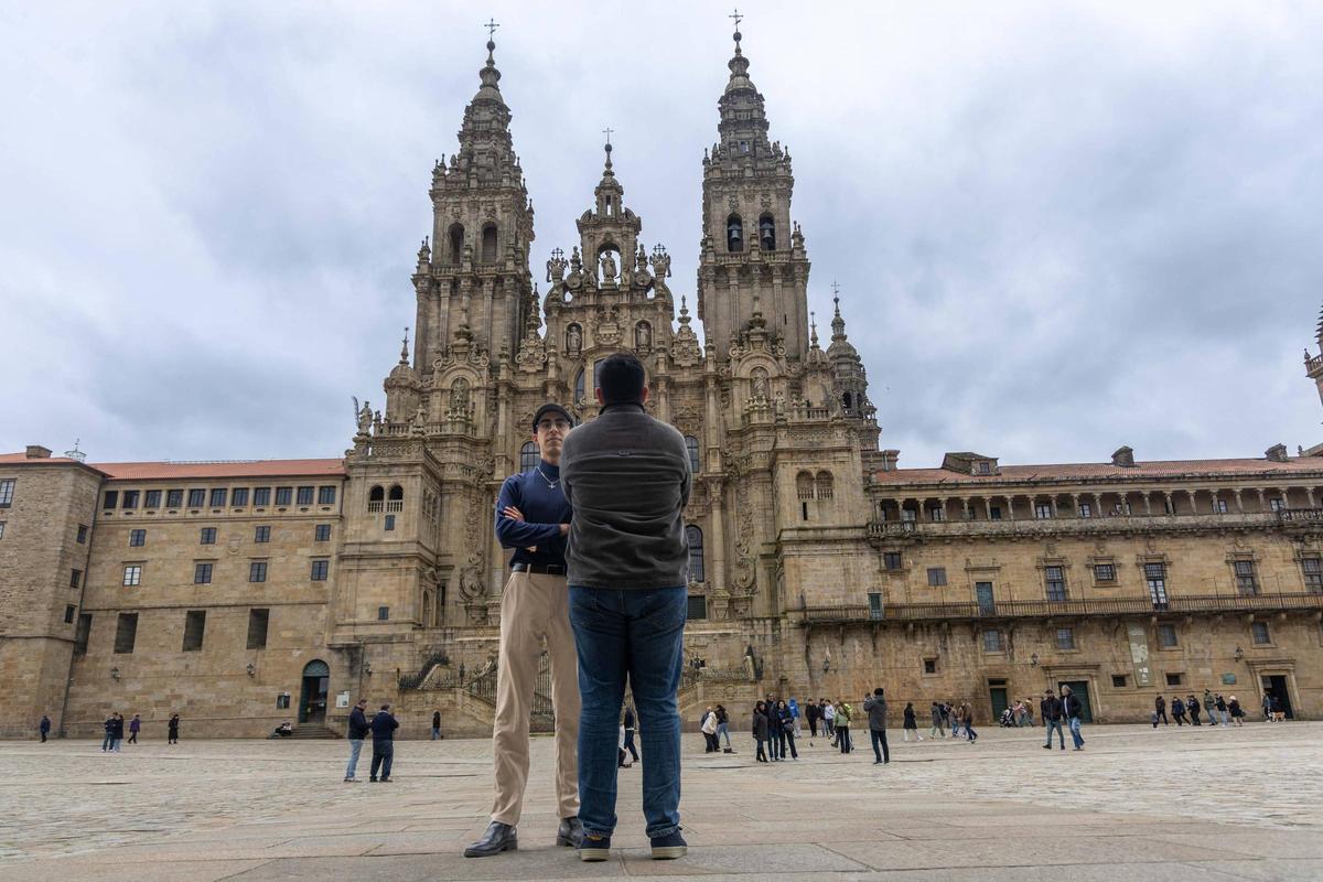 Nima (de frente) y Mehdi (de espaldas) posan ante la Catedral de Santiago