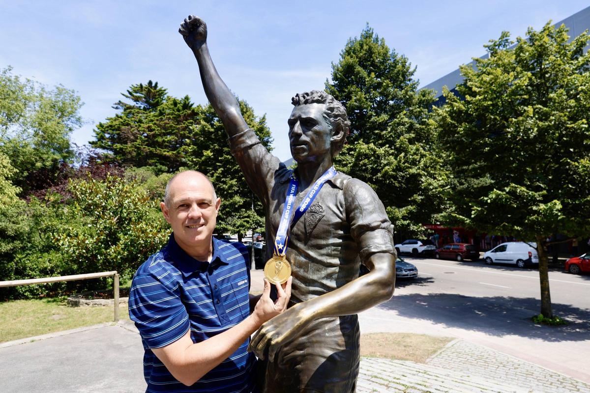 Juanjo González, ayer, con su medalla, junto a la estatuta de Quini.