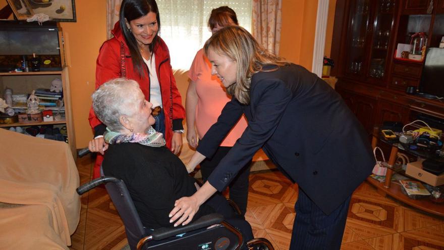 La conselleira de Política Social, Fabiola García, visita a una persona dependiente en su casa de Mos junto a la alcaldesa del Concello, Nidia Arévalo. |   // D.P.