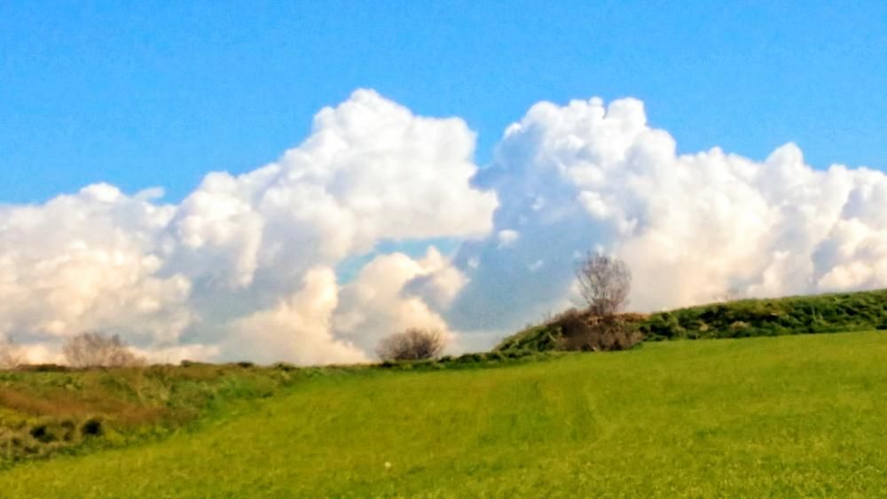 Nuvolades. Del darrere dels camps, que ja verdegen, es veuen sortir unes grans castelleres, tot i que el cel de moment és ben serè