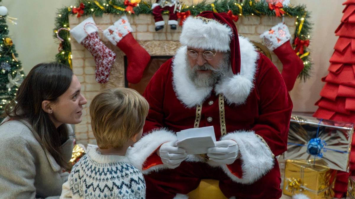 Un niño entrega su carta a Santa Claus en la Casa de Papá Noel de Nules, el año pasado.