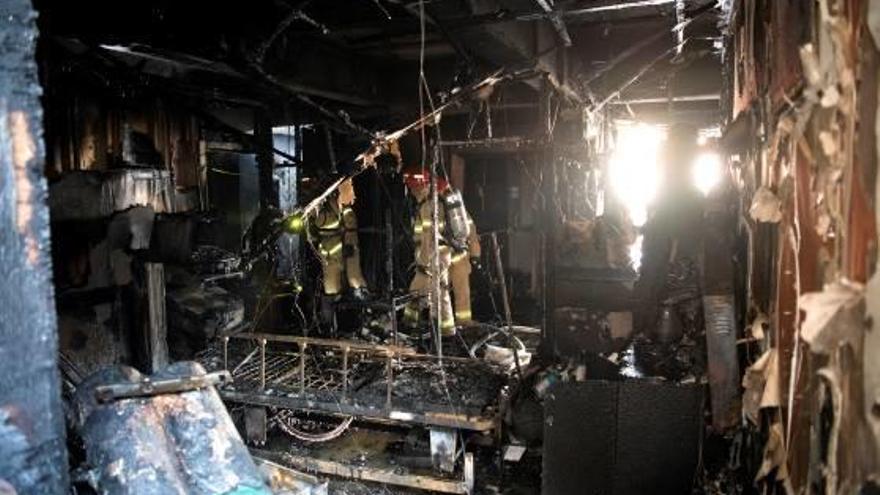 Els bombers inspeccionen una de les zones de l&#039;hospital més devastades per les flames.