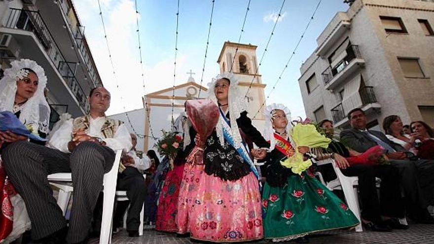 Dos niñas a espaldas de la iglesia de San Jaime y Santa Ana llevan ramos durante la Ofrenda a San Juan, que es el acto inaugural de las Hogueras.