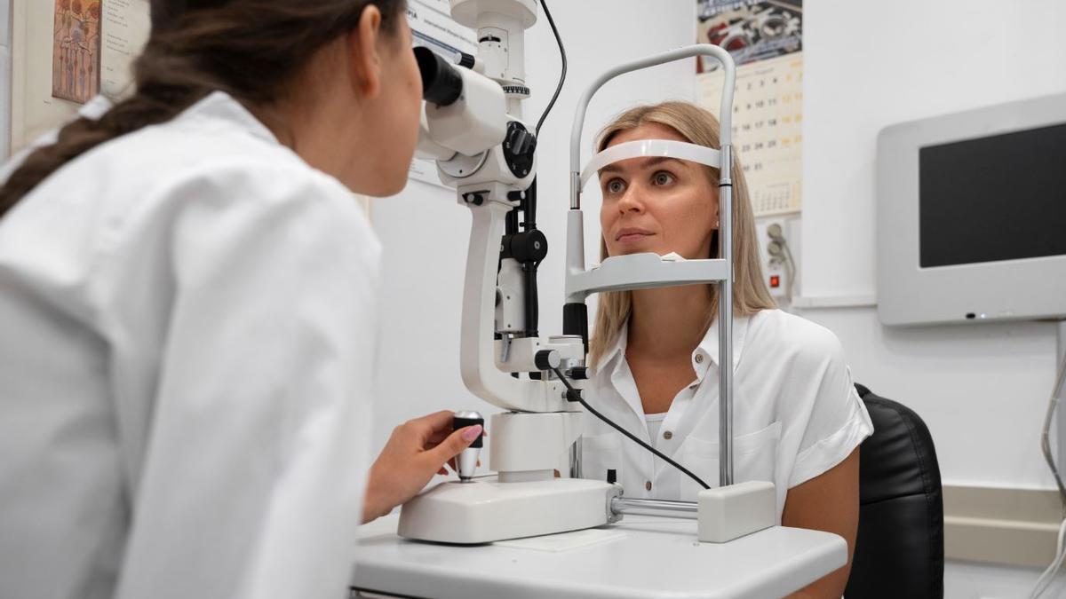 Una óptico-optometrista realiza una revisión ocular a una paciente.