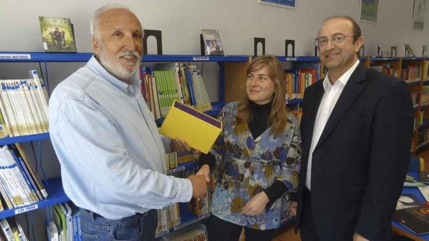 Martín Barrigós entrega la obra de Alejo a la directora de la biblioteca de Almeida en presencia del alcalde.