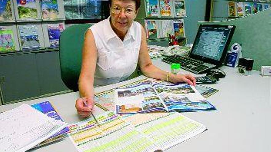 Una agente de viajes muestra un folleto con paquetes vacacionales. / JESÚS REGAL