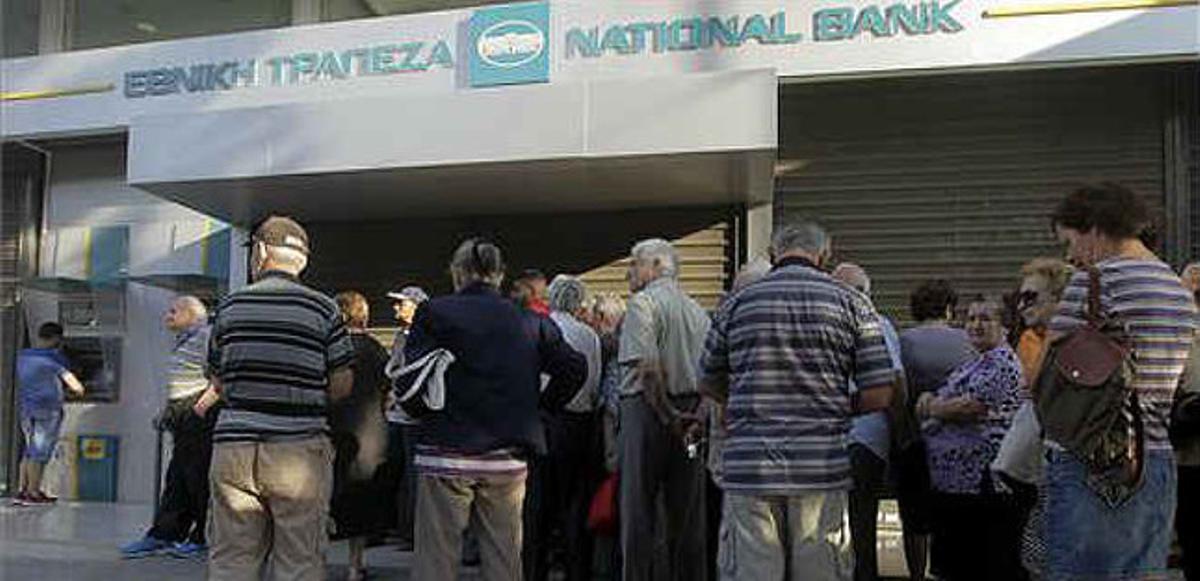 Ciudadanos griegos hacen cola en una sucursal del National Bank de Grecia a la espera de sacar su dinero. 