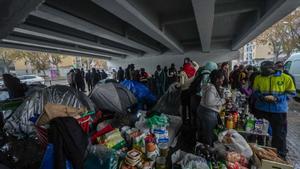 Algunos de los desalojados del B9, instalados con tiendas de campaña bajo una salida de la C-31 en Badalona para protegerse de la lluvia