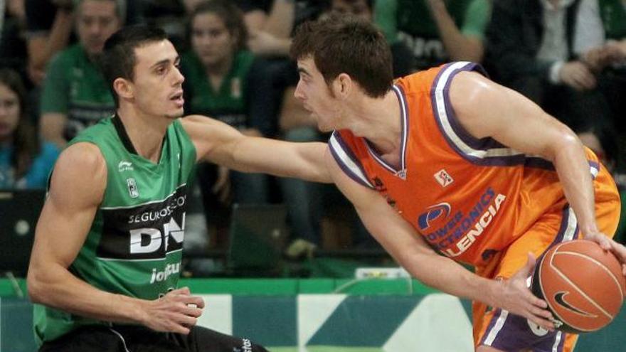 El alero Víctor Claver, del Valencia (d), trata de avanzar con la pelota bajo la defensa del también alero del Joventut Pere Tom s (i), durante el partido correspondiente a la quinta jornada de la Liga ACB que ambos equipos han disputado esta tarde en el pabellón Olímpico de Badalona.