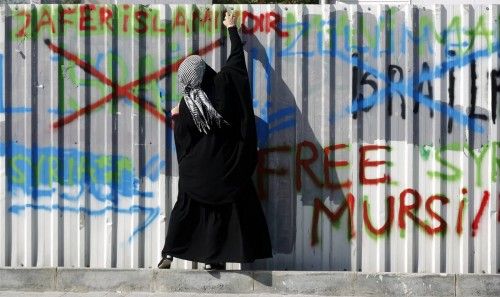 A pro-Palestinian demonstrator sprays graffiti during an anti-Israeli protest outside the Justice Palace in Istanbul