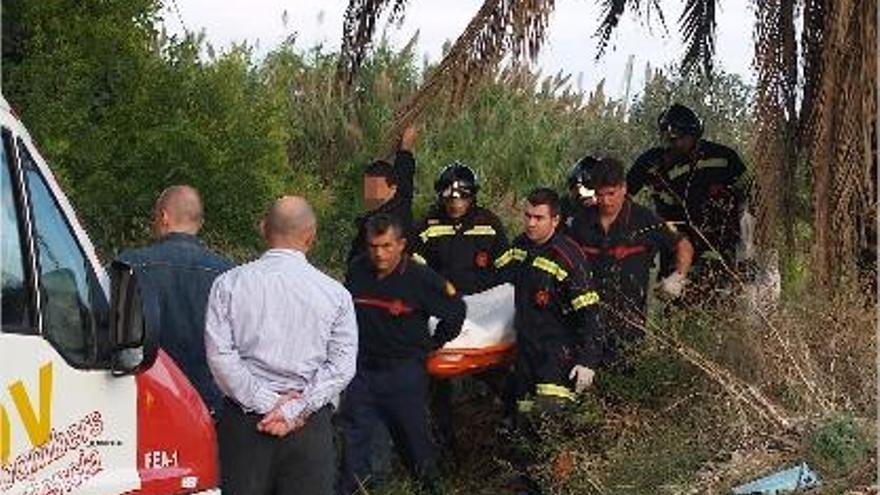 Los bomberos sacan el cadáver del septuagenario, quien había quedado atrapado en el granado.