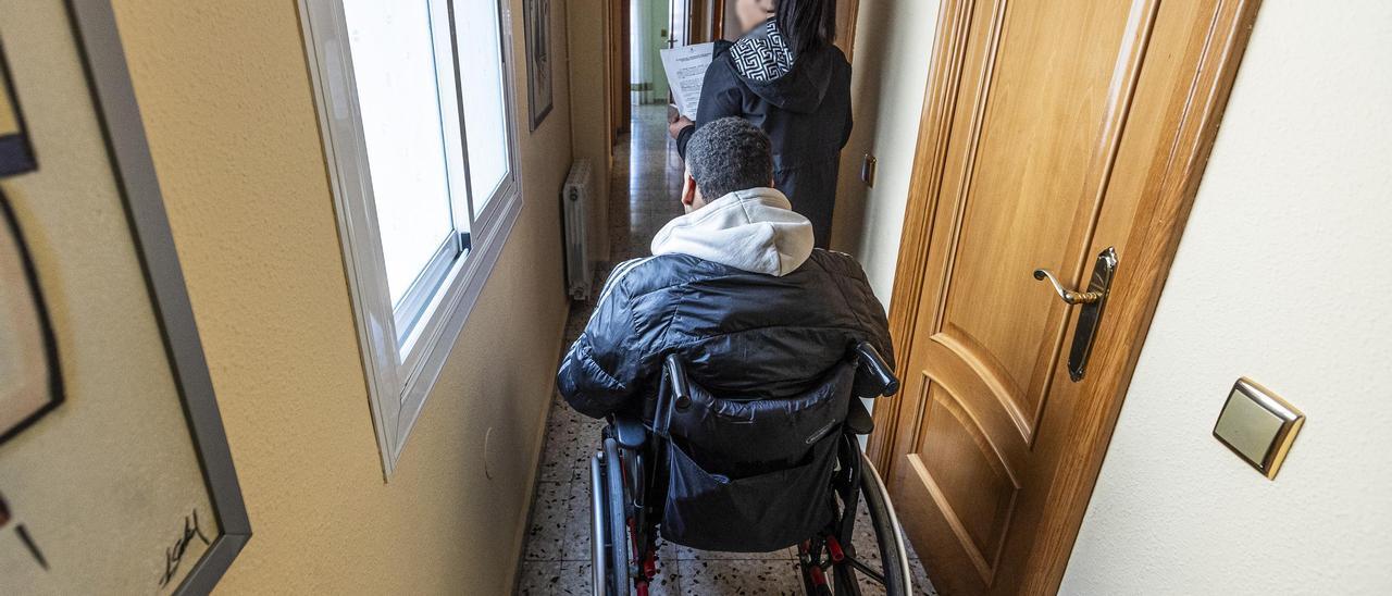 Josefina y su hijo en silla de ruedas con la orden de desahucio que podría obligarles a abandonar su vivienda en Alicante.