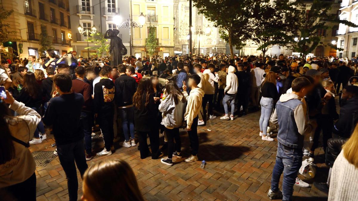 Un grupo de jóvenes bebiendo en la calle.