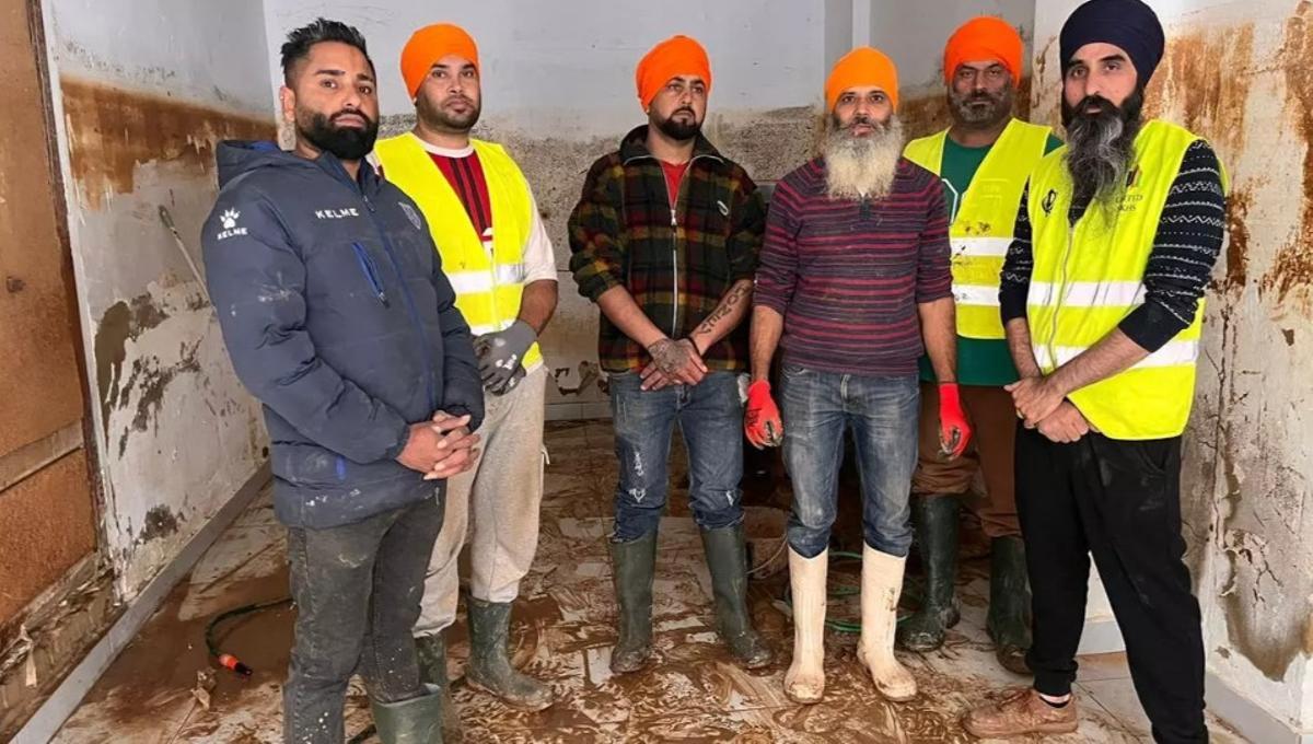 Miembros de la comunidad SIJ colaboran en la limpieza de un bajo en Paiporta.