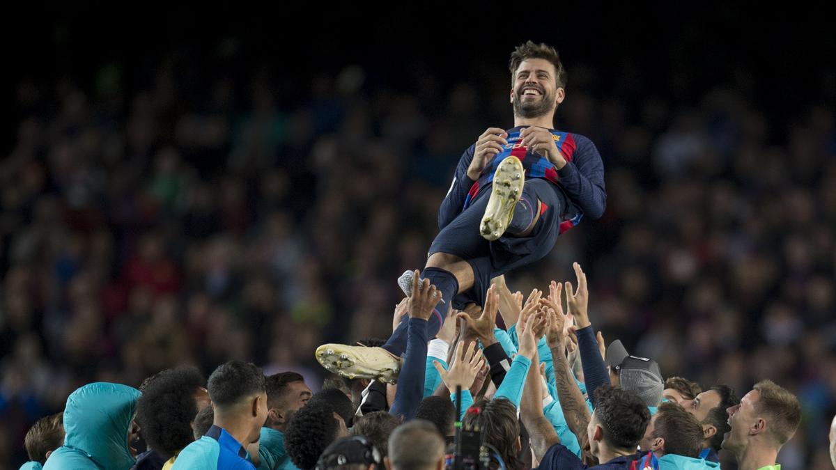 Gerard Piqué manteado por sus compañeros tras jugar con el Barça su último partido en el Camp Nou.