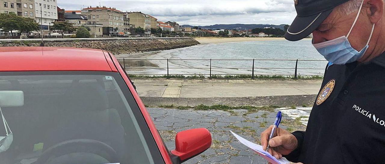 Un oficial de la Policía, ayer en un simulacro de control de tarjetas frente a la playa de Rodeira.