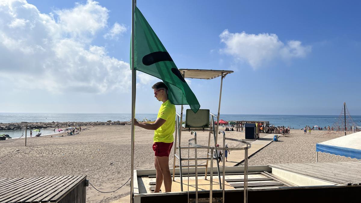 Socorrista de la playa de Vinaròs junto a la bandera diseñada con código &#039;Color ADD&#039;