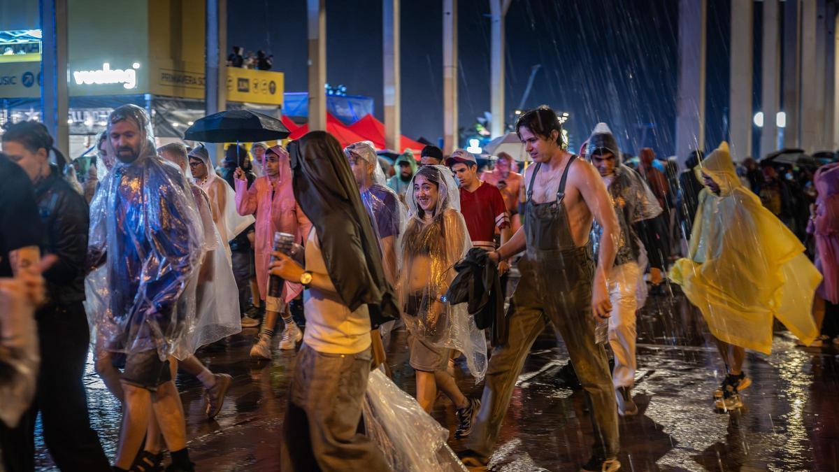 Diverses persones fugint de la pluja en la primera jornada del Primavera Sound