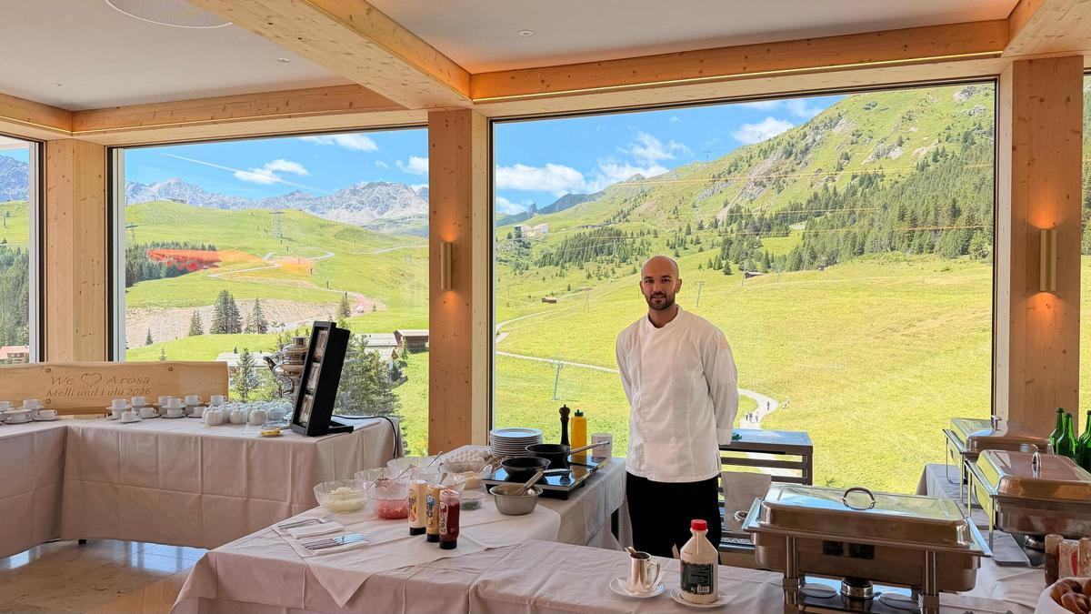 Rubén, en el bufé de desayunos del hotel donde trabaja en Suiza, con las montañas al fondo.