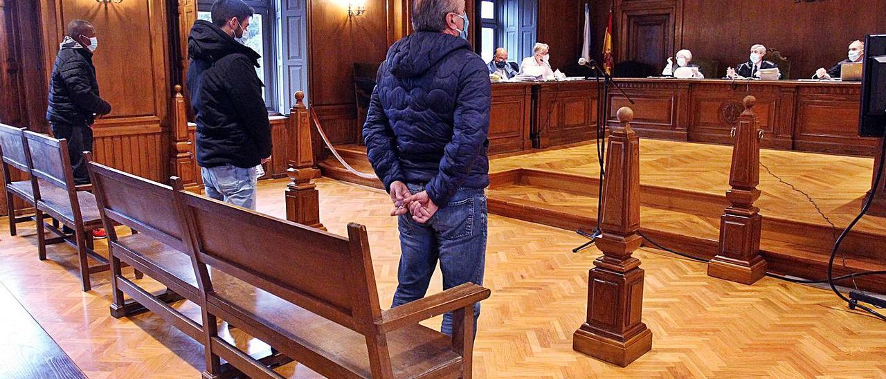 Los tres acusados, de pie, durante el juicio que ayer finalizó en Pontevedra. |   // POOL MÓNICA PATXOT