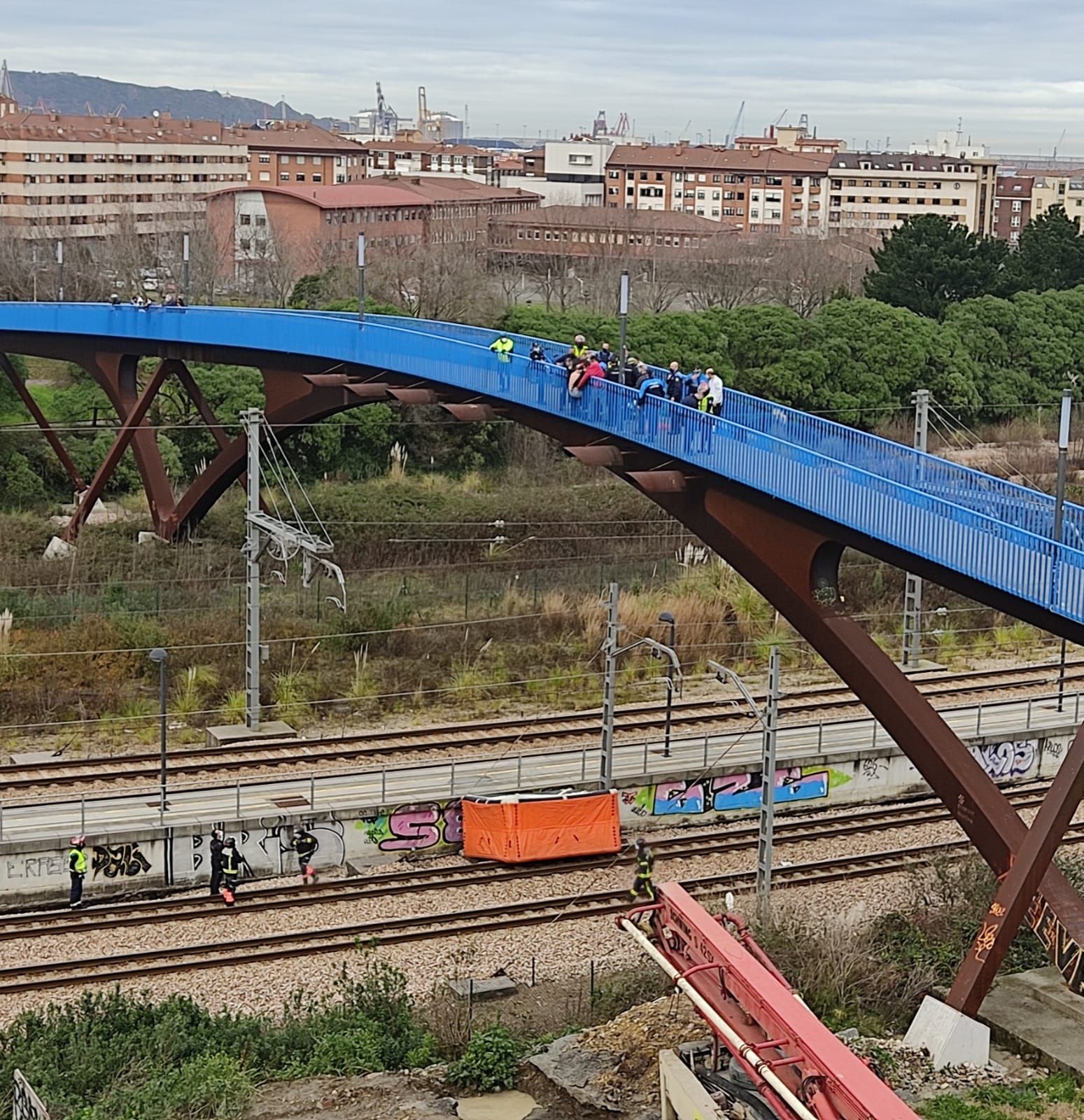 Momento en el que rescatan al joven, con la colchoneta de los bomberos en las vías.