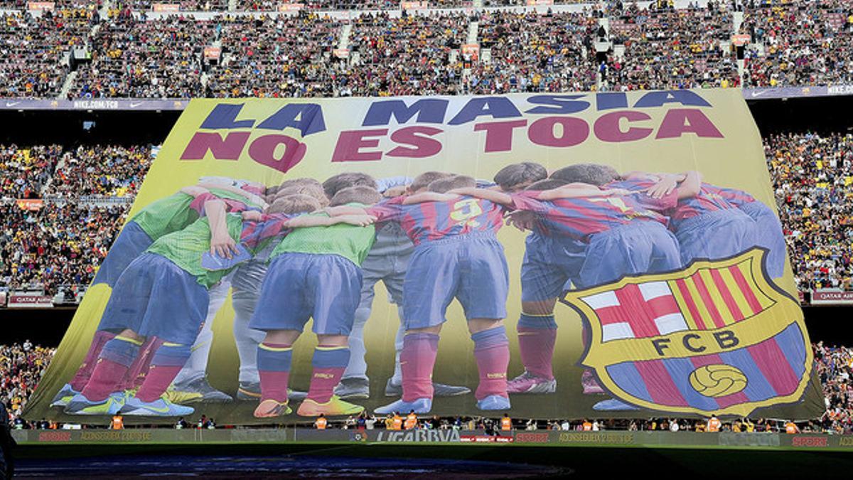 La pancarta con el lema 'La Masia no se toca' que los aficionados azulgranas han desplegado en el Camp Nou antes del partido contra el Betis