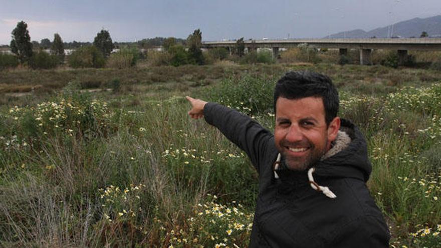 Carlos Alonso, en la zona aproximada donde iría la pasarela de madera de 260 metros de largo y al fondo, el puente de la autovía.