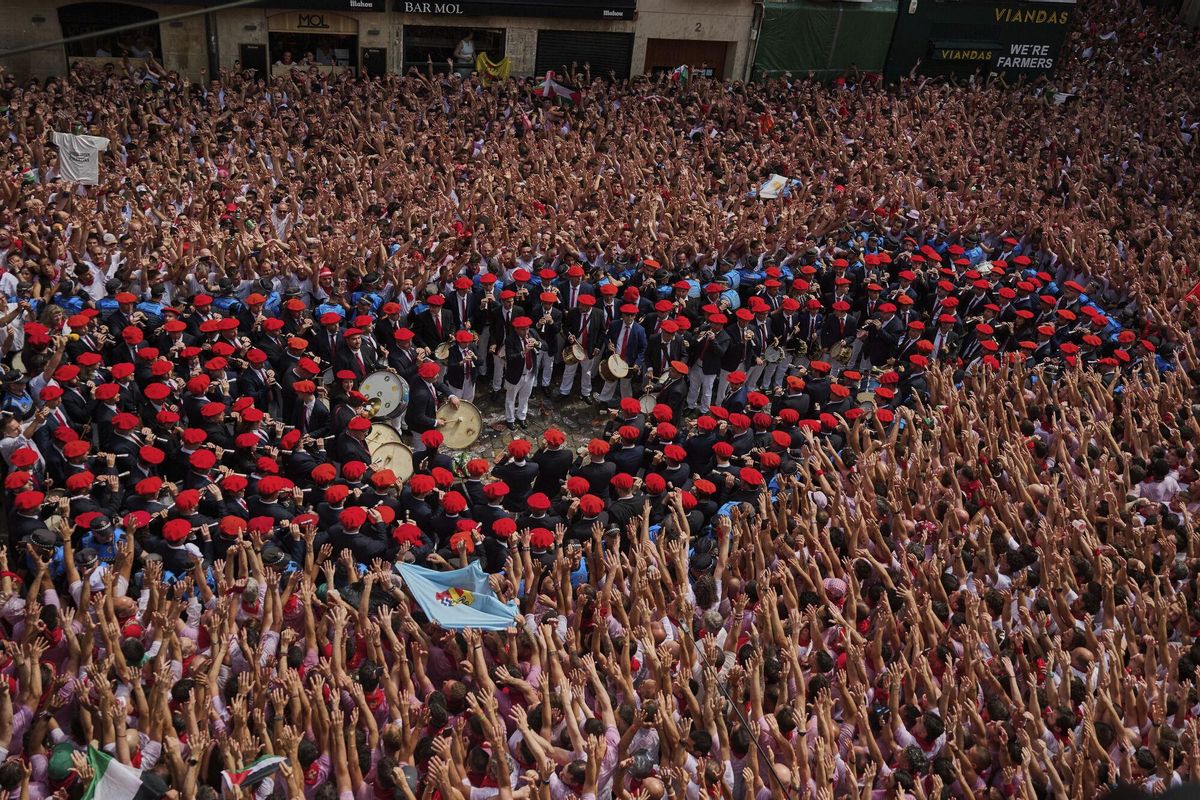 A municipal music band makes its way through the crowd as revelers pack the main square during the start of nine days of uninterrupted partying in Pamplonas famed running-of-the-bulls festival in Pamplona, Spain, Sunday, July 6, 2025. (AP Photo/Miguel Oses). EDITORIAL USE ONLY/ONLY ITALY AND SPAIN