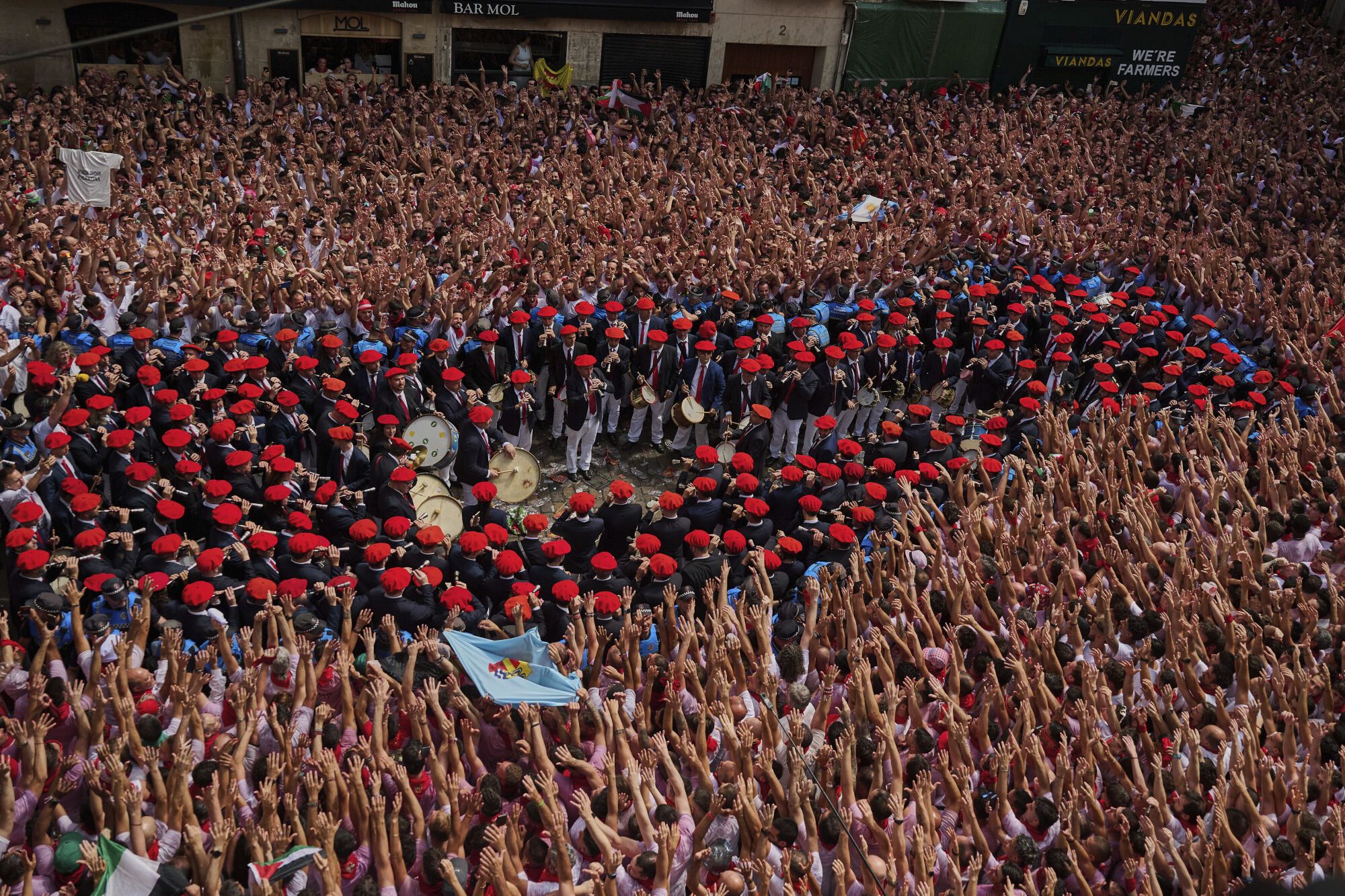 A municipal music band makes it's way through the crowd as revelers pack the main square during the start of nine days of uninterrupted partying in Pamplona's famed running-of-the-bulls festival in Pamplona, Spain, Sunday, July 6, 2025. (AP Photo/Miguel Oses). EDITORIAL USE ONLY/ONLY ITALY AND SPAIN