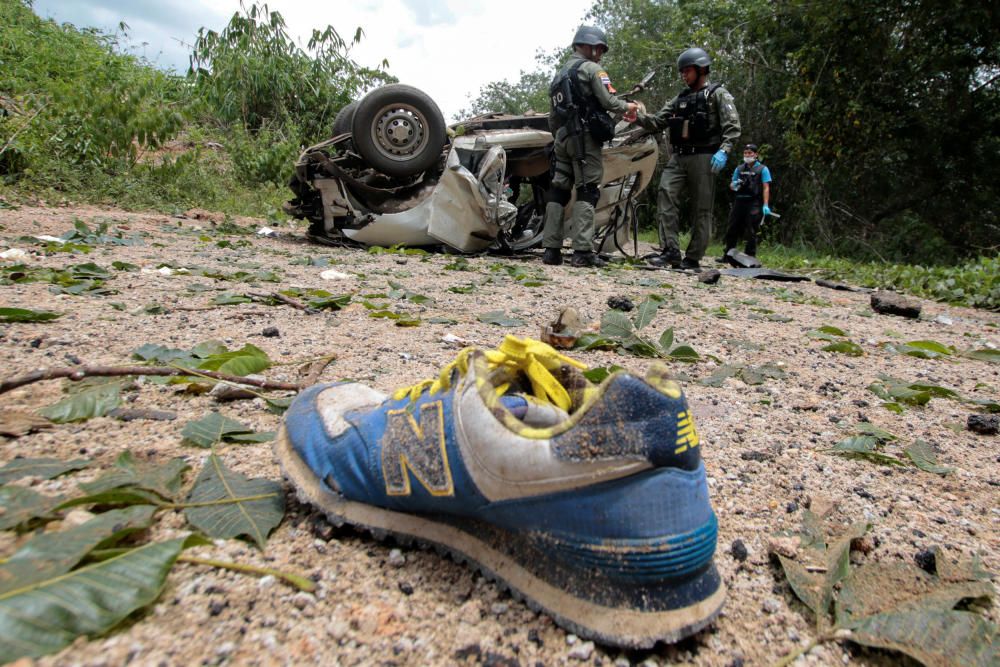 Military personnel inspect the site of a bomb ...