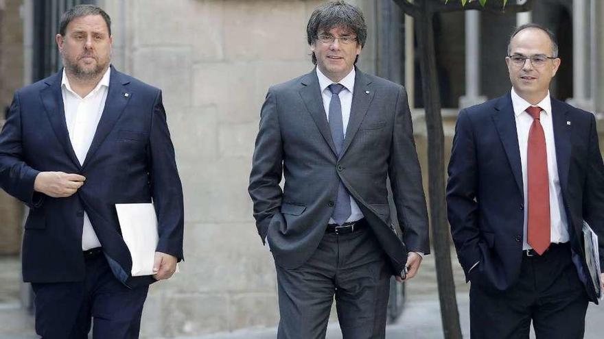 De izquierda a derecha, Oriol Junqueras, Carles Puigdemont y Jordi Turull, a su llegada ayer a la reunión del Ejecutivo catalán. // Efe