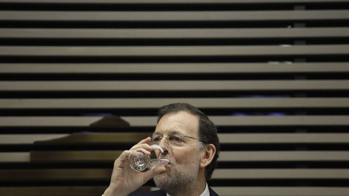 Rajoy bebe agua durante un encuentro con empresarios españoles y brasileños, el jueves, en Sao Paulo.