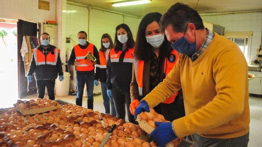 Fernando Silva y Marta GIráldez, en primer plano, con el bollo y un grupo de voluntarios. // Iñaki Abella