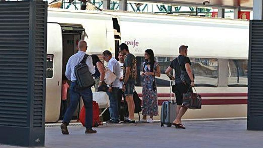 Varias personas suben al tren en la estación de Zamora.