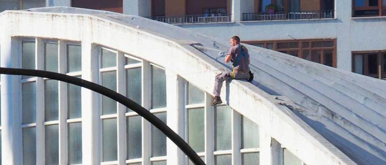 Un operario instala las guías para colocar la iluminación, en la Pola.