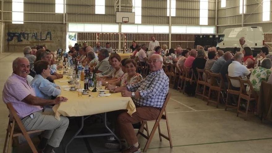 Los asistentes al encuentro durante la comida en el polideportivo santallés.