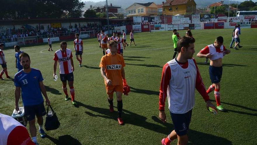 Los jugadores del Alondras salen con rostros de tristeza del césped del campo de O Morrazo al finalizar el choque. // Gonzalo Núñez